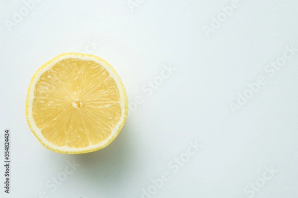 Fototapeta one cut lemon isolated on a white table. view from above