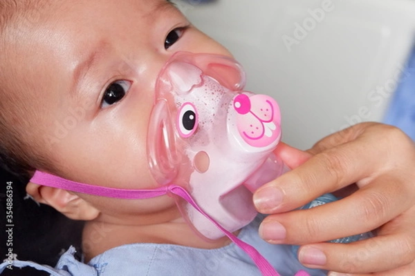 Obraz Sick boy inhalation therapy by the mask of inhaler. Boy is sick with Respiratory Syncytial Virus. Patient Boy use inhalation with Nebulizer mask at hospital. The baby are spraying bronchodilators .