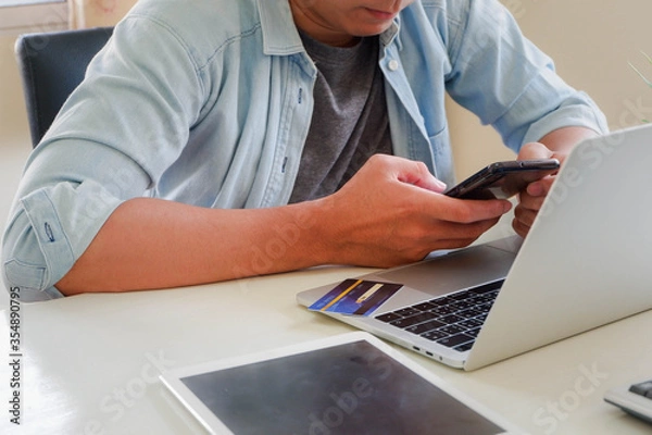 Obraz Hands holding credit card and using laptop. Online shopping