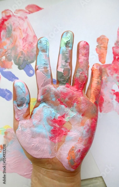 Fototapeta the imprint of a human hand with colorful paint and paint on the hand