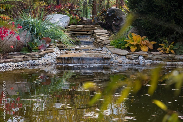 Fototapeta artificial waterfall with a pond