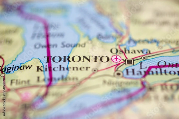 Fototapeta Shallow depth of field focus on geographical map location of Toronto city Canada America continent on atlas