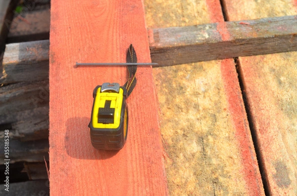 Obraz Construction roulette lies on wooden boards, construction work.