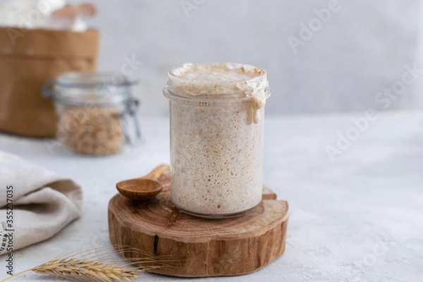 Obraz Active bubbly sourdough bread starter, healthy fermentation process on light table