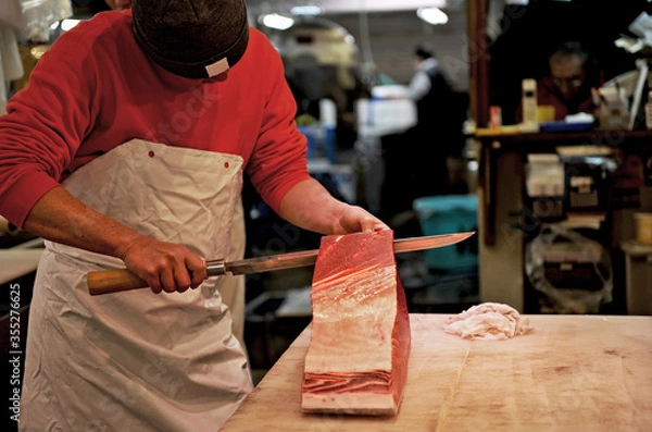 Fototapeta Tsukiji, Tokyo, Japan - March 25, 2015 : One of the most famous seafood market in the world, Bursting chefs in action as they fillet the fish.