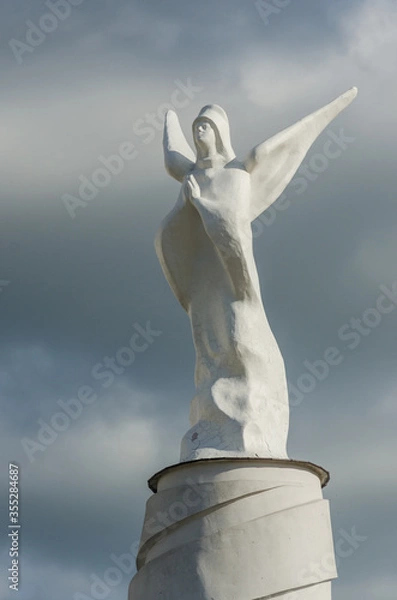 Obraz Plain angel statue on a dark sky background