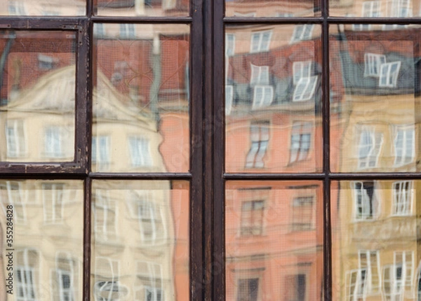 Obraz Old colorful buildings deformed reflection on window