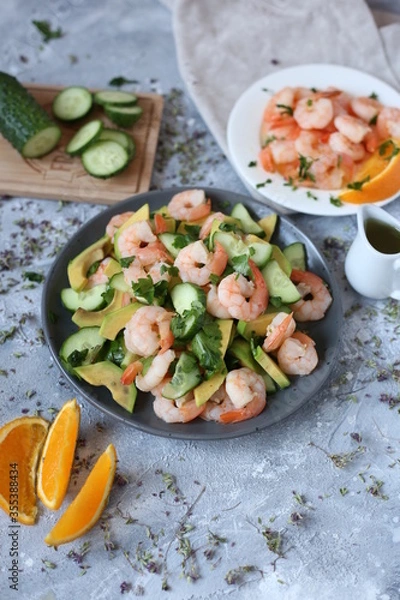 Fototapeta fresh shrimp, avocado and cucumber salad. shrimp fried in orange sauce