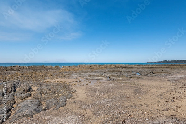 Fototapeta Empty Large Rocky Coastal Seaside Scene and Beach on a Sunny Day