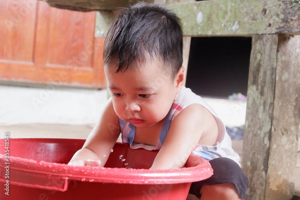 Obraz An Asian boy is playing with a water balloon. Playing is learning.