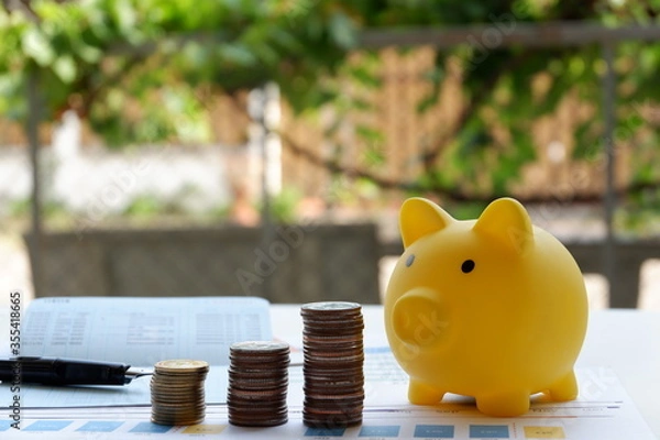 Obraz Coin and yellow piggy bank on the white table, Saving money concepts. Garden background