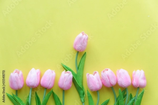 Obraz Yellow and pink tulips placed on a wooden table.