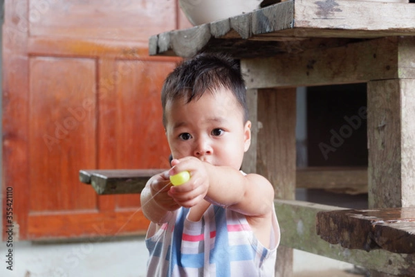 Obraz An Asian boy is playing with a water balloon. Playing is learning.
