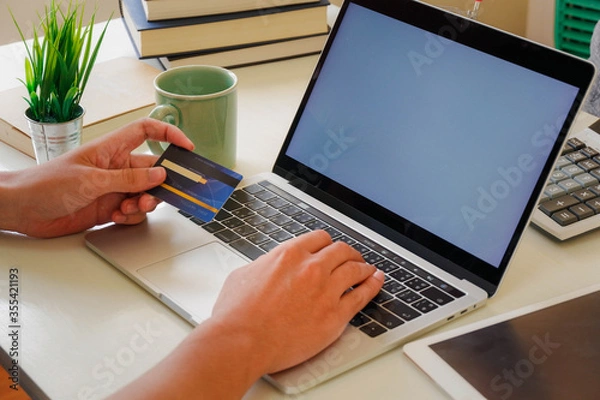 Obraz Hands holding credit card and using laptop. Online shopping