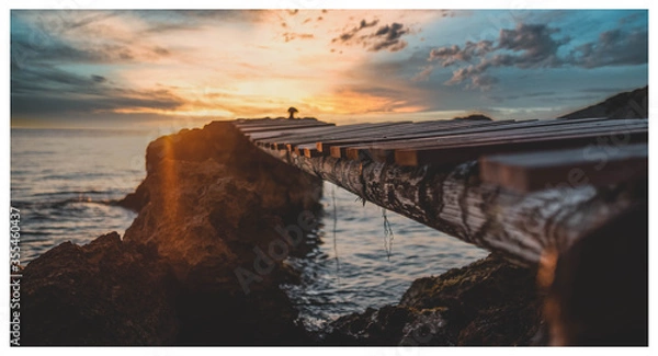 Fototapeta sunset over the ocean over the bridge
