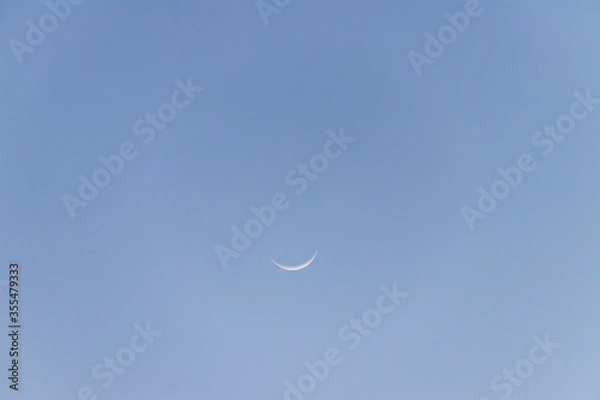 Fototapeta Crescent moon on blue sky. Look like a smile on a good day.