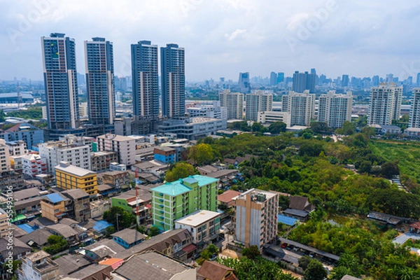 Fototapeta View from the high floor of the streets of Bangkok. Tall buildings and roofs of small houses. City landscape