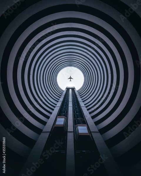 Fototapeta Look up Architecture symmetry cycle building with the plane on center