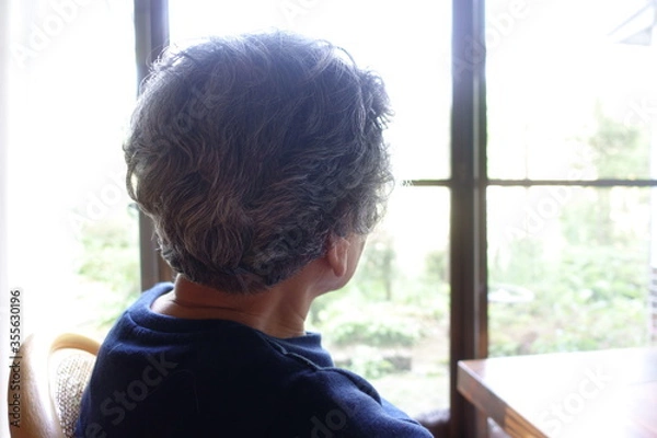 Fototapeta 窓際に座って外を眺める日本のおばあちゃん