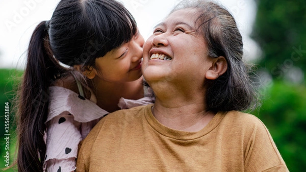 Fototapeta Grandmother and granddaughter enjoyed in the garden.Asian family conception