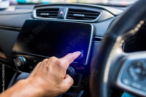 Fototapeta Selective focus to driver's finger touch on power button the smart monitor screen at the console in the car. The concept of smart car.