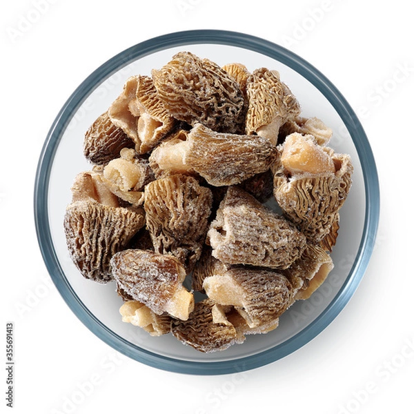 Fototapeta Frozen morel mushrooms in a glass plate on a white background. Isolated frozen mushrooms. Top view. 