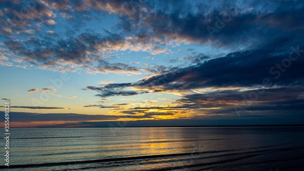 Obraz Beautiful dramatic clouds during sunset on the beach.