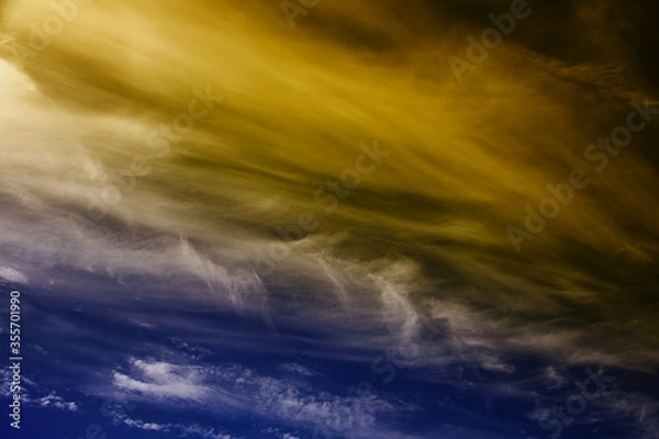 Obraz Dramatic cirrus clouds and vapour trails with color.