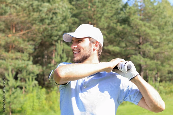 Fototapeta Golfer hitting golf shot with club on course while on summer vacation.