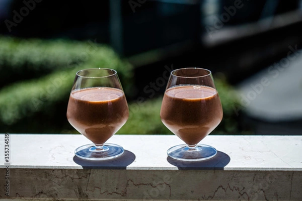 Obraz Healthy fruit smoothie served in the garden.