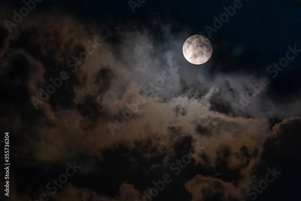 Fototapeta Full Moon peaking through beautiful cloudscape