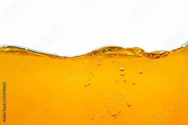 Fototapeta Closeup process of splashing of green tea. Macro shot of liquid in transparent glass. Abstract background with splashes, sprays, waves, bubbles of lager beer, whiskey, cognac, rum, brandy.