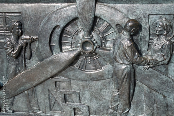 Obraz Bronze bas-relief showing women working in the manufacturing of aircrafts, World War II Memorial in Washington, D.C.