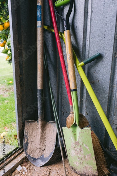Obraz Garden Tools leaning in garden shed covered in dirt