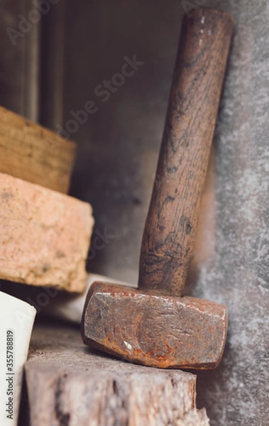 Fototapeta Old used Rusty Hammer leaning again steel sitting on a timber ledge