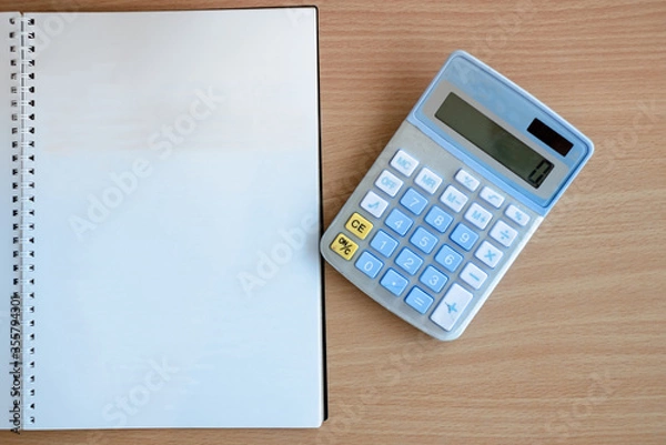 Fototapeta Stationary and blank books on the table, pencil set ,cup of coffee and calculator on wood table , copy space of stationary , working space, space work from home