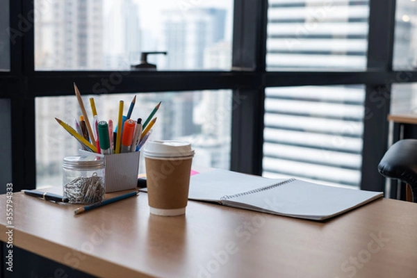 Fototapeta Stationary and blank books on the table, pencil set ,cup of coffee and notebook on wood table , copy space of stationary , working space, space work from home