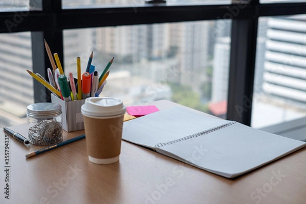 Fototapeta Stationary and blank books on the table, pencil set ,cup of coffee and notebook on wood table , copy space of stationary , working space, space work from home