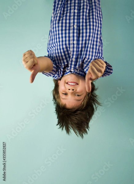 Obraz Happy boy hanging upside down, holding his hands in front of him