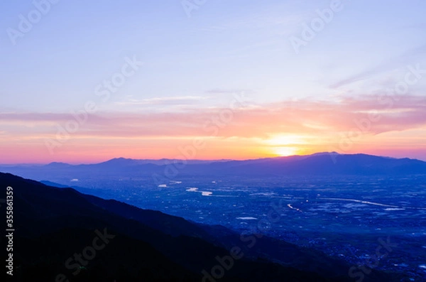 Fototapeta 山に沈む夕焼けと河と平野