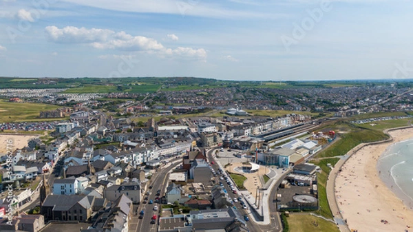 Fototapeta Aerial view on sandy Beach and coast of Atlantic Ocean in Portrush Northern Ireland, Top view on small coastal town 