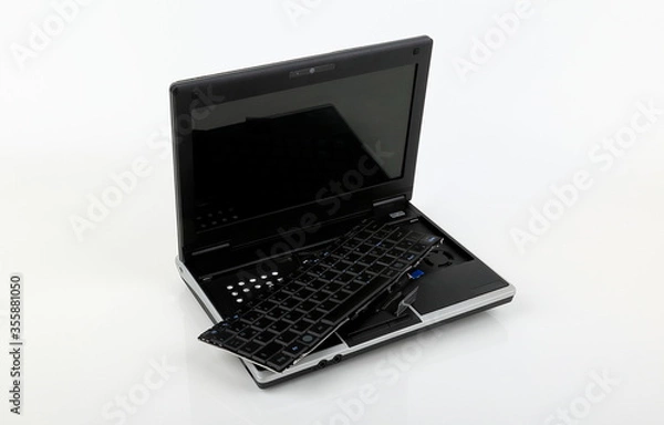 Fototapeta A damaged notebook keyboard and electronic parts.