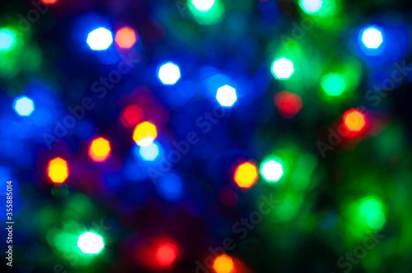 Fototapeta Holiday bokeh. Abstract Christmas background. Blurred multicolored garland.