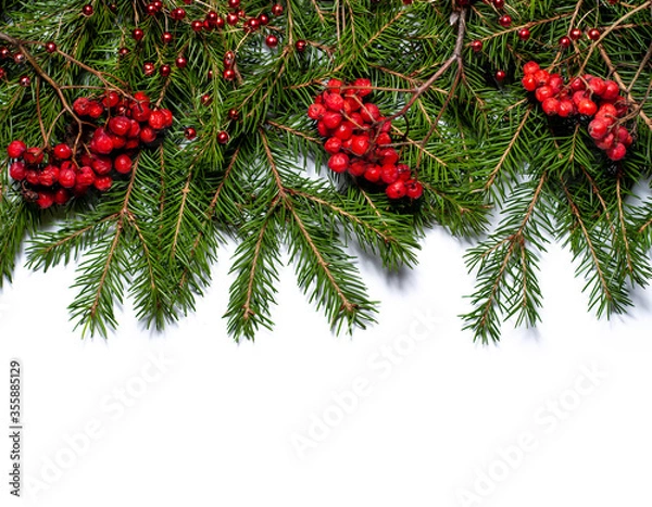 Fototapeta Spruce branches with rowan berries and Christmas decorations isolated on white background. Design template for New Year and Christmas.