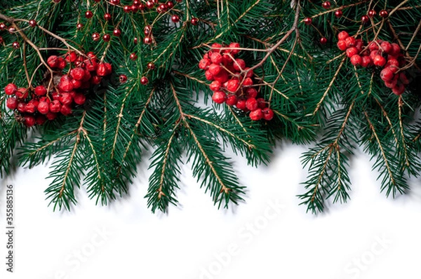 Fototapeta Spruce branches with rowan berries and Christmas decorations isolated on white background. Design template for New Year and Christmas.