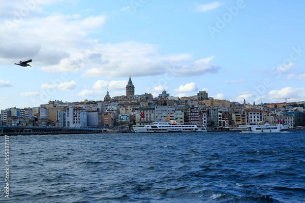 Fototapeta Istanbul, Turkey - February 23, 2017: A view from the historic bridge where amateur fishermen always fishing, along with pedestrian and car crossing. Galata Tower seen in the background.