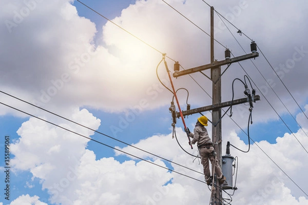 Fototapeta The power lineman use clamp stick (insulated tool) to closing a transformer on energized high-voltage electric power lines. The power lineman must be trained because it is a risky job.