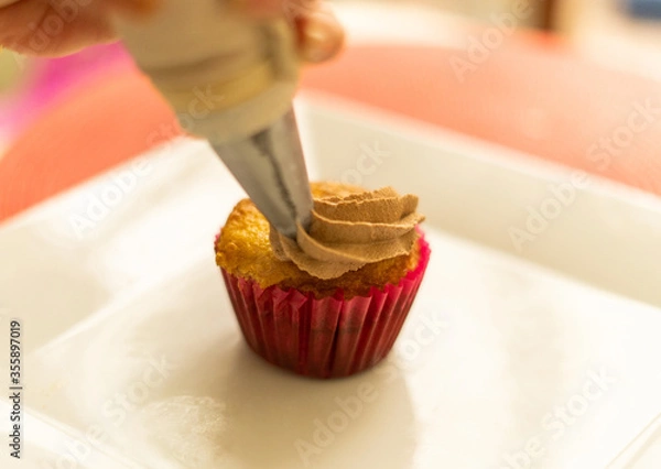 Fototapeta decorating cupcake in the table