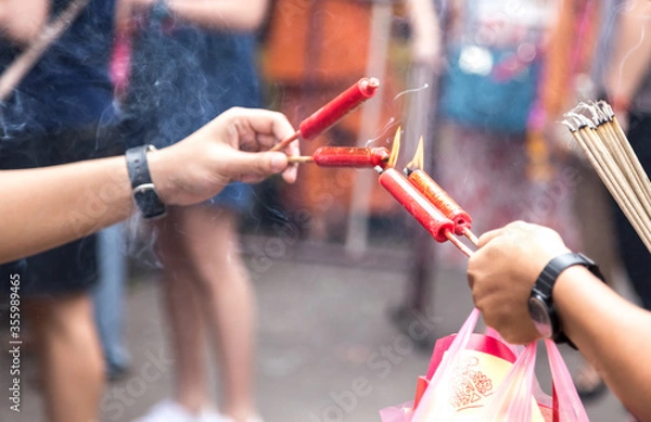 Fototapeta Chinese red candle with fire for praying inside Chinese temple during Chinese new year