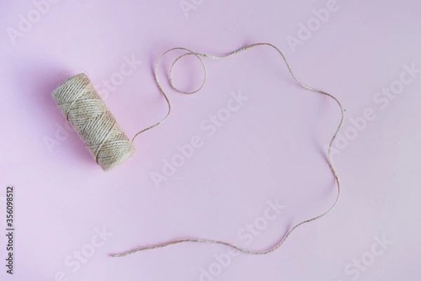 Fototapeta Jute twine on the purple background. View from top, copy space. 